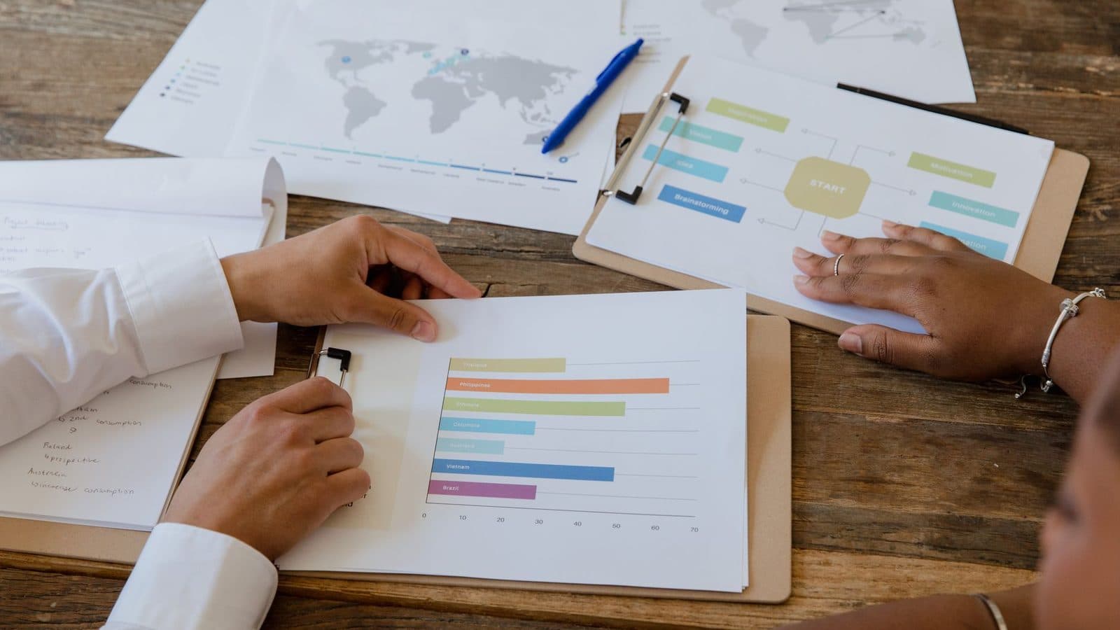 Documentos e planilhas de planejamento sobre a mesa durante reunião de trabalho