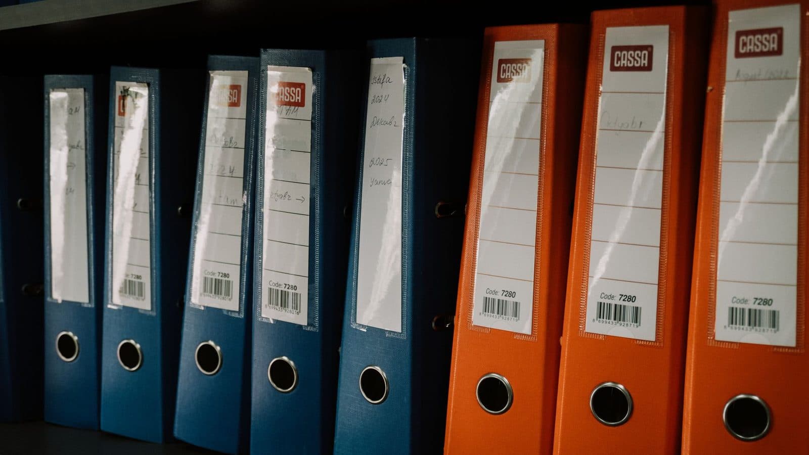 Prateleira com pastas de arquivo organizadas por cor